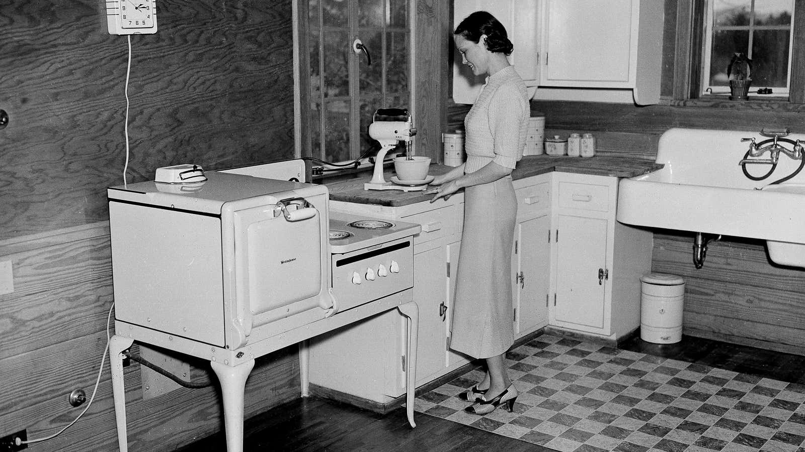 A housewife is shown as she prepares a meal in her all-electric kitchen in Morris, Tenn.