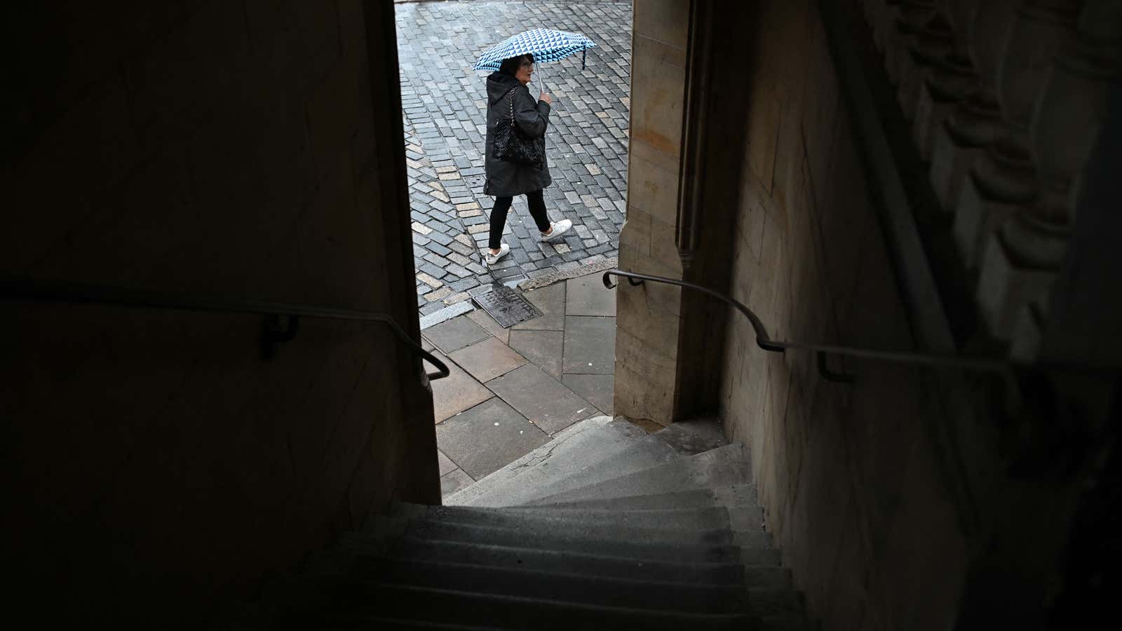 A pedestrian holding an umbrella walks in the rain in Chester on November 17, 2022.