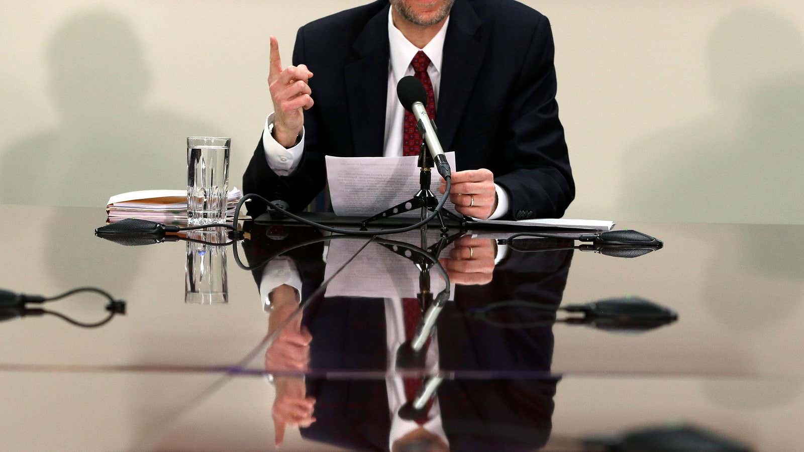 FILE – In this Feb. 5, 2013, file photo, Congressional Budget Office Director Douglas Elmendorf is reflected on a table as he speaks about the…