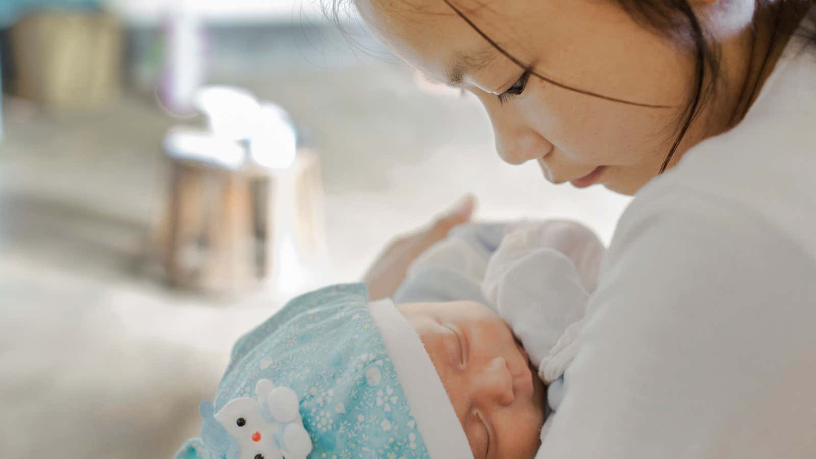 Cai, 16, holds her 2-month-old son at home.