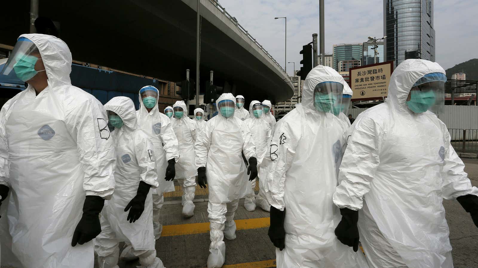 Health workers in full protective gear walk at a wholesale poultry market before culling poultry in January.