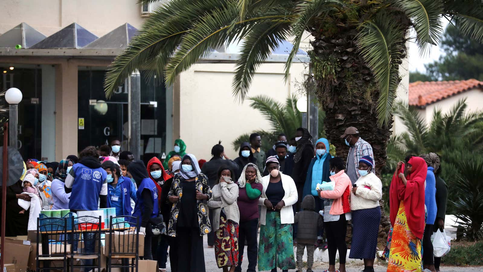 Refugees line up to receive hand sanitizers at a refugee shelter in Kranidi, Greece.