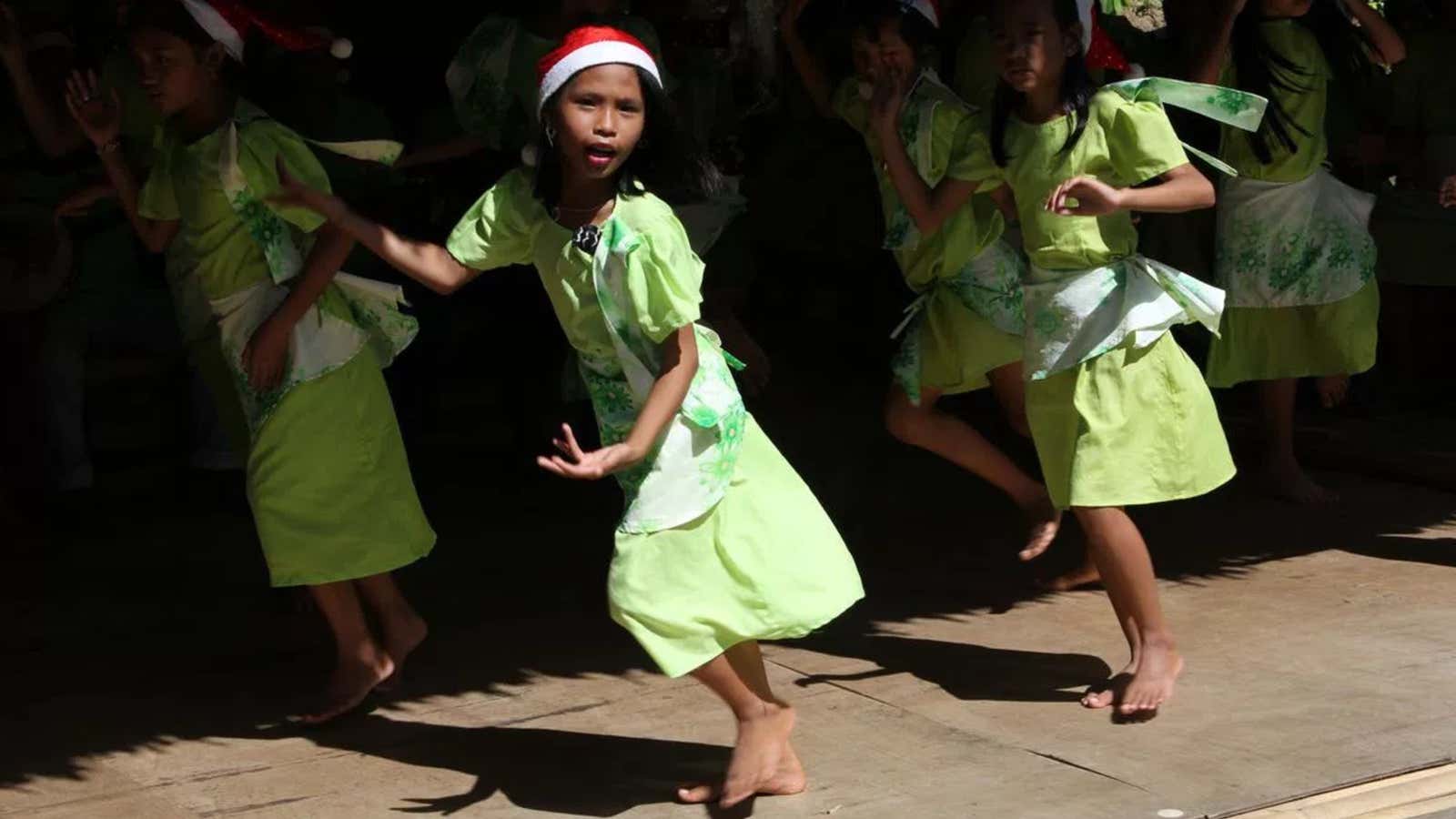 A group of children dance in a performance organized by a local church to raise money after Typhoon Bopha on the island of Bohol in the Philippines.