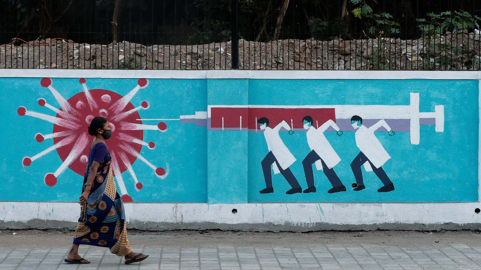 A woman walks past  graffiti in Mumbai.