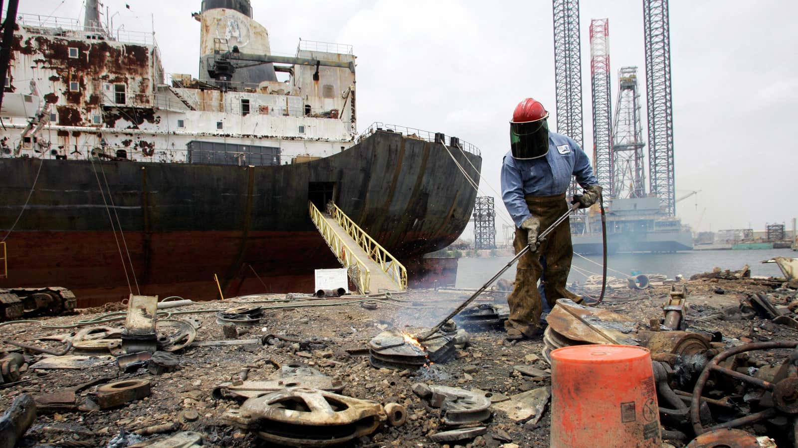 A worker uses a torch to breakdown ship parts for recycling at International Shipbreaking Ltd., in Brownsville,  Texas, Thursday, May 1, 2008. The group began recycling a 42-year-old Adonis, purchased for an unprecedented $1.1 million, background, last week.  (AP Photo/Eric Gay)