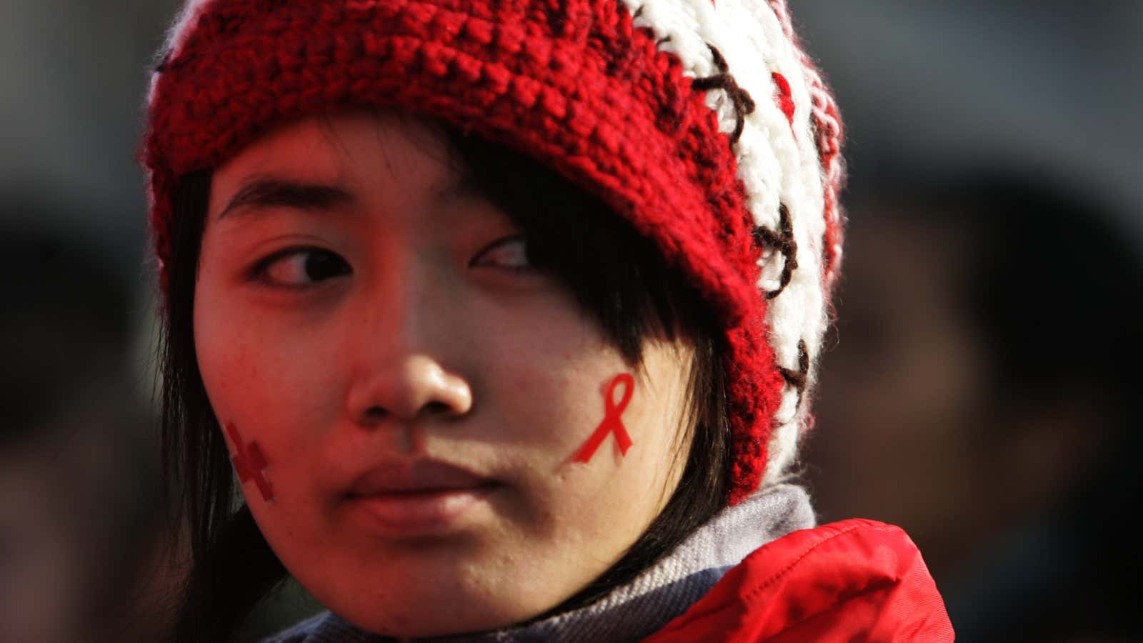 A girl with a red ribbon, showing her support for people living with HIV.