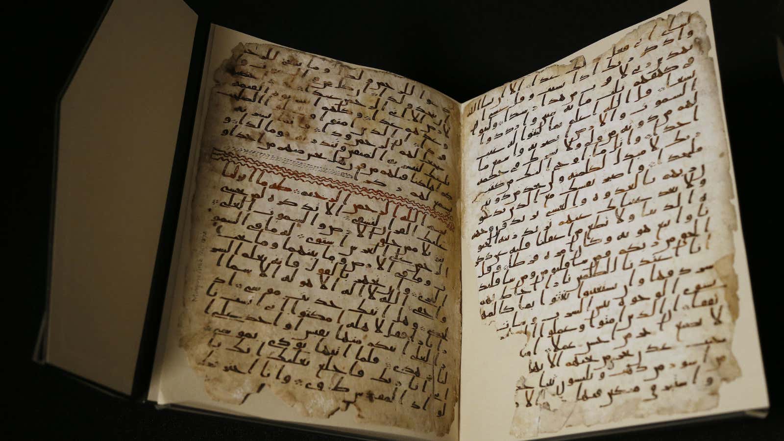 A university assistant shows fragments of an old Quran at the University in Birmingham.