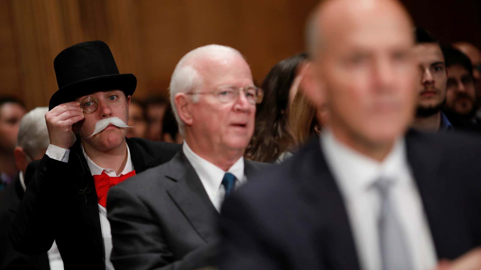 A man dressed as the Monopoly man looks on as CEO of Equifax, Inc., testifies before the U.S. Senate Banking Committee.