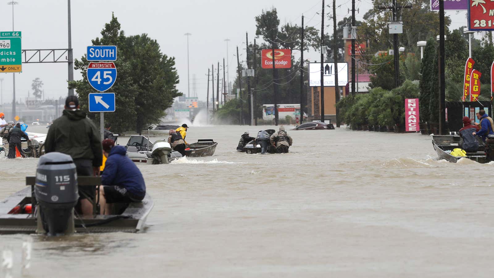 Volunteers are rescuing stranded citizens in boats.