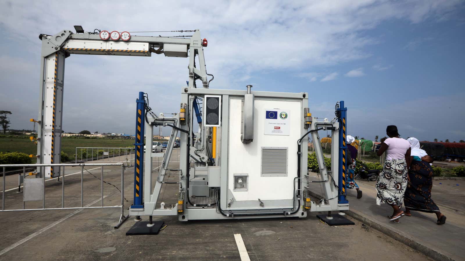 People walk past the newly installed but yet to be commissioned scanner donated by the European Union to ECOWAS at the border with Benin Republic, in Seme, Nigeria July 19, 2019.