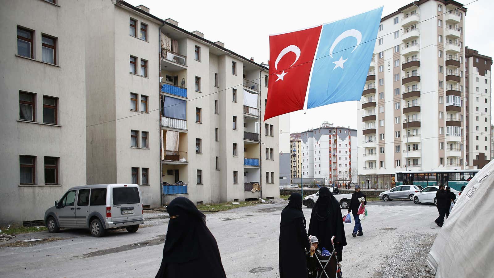 Uighur refugee women walk where they are housed in a gated complex in the central city of Kayseri, Turkey.