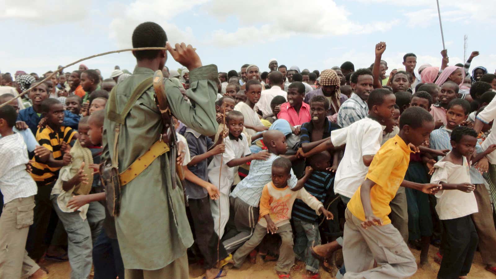 A member of Al Shabaab controls residents as they participate in a demonstration against Kenyans&#39; incursion inside Somalia in Mogadishu. The terrorist group is now fighting for the control of the media.