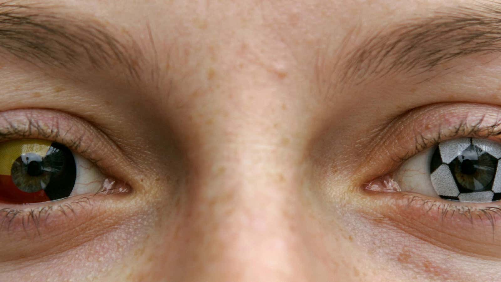 German optician Stephanie Berndt wears a soccer ball and German flag printed pair of contact lenses in Munich February 6, 2006. A set of  ‘Magic Lens’ contact lenses with images of one soccer ball and a German flag cost 45 euros (54 U.S. Dollars). – PBEAHUNSJFE