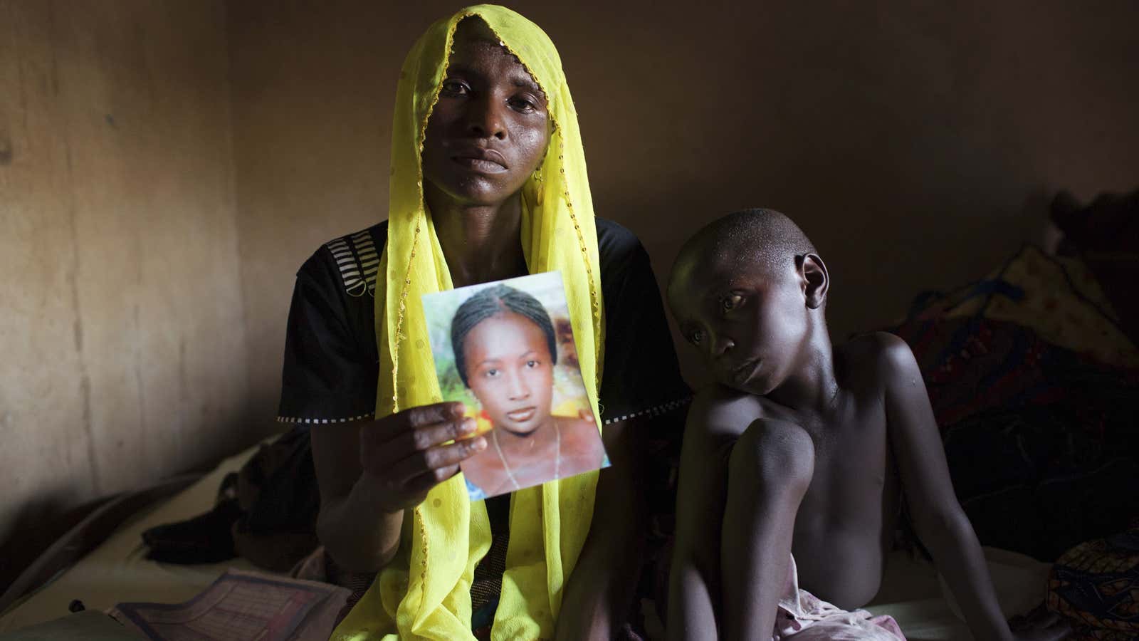 A mother holds up a photo of her abducted daughter.