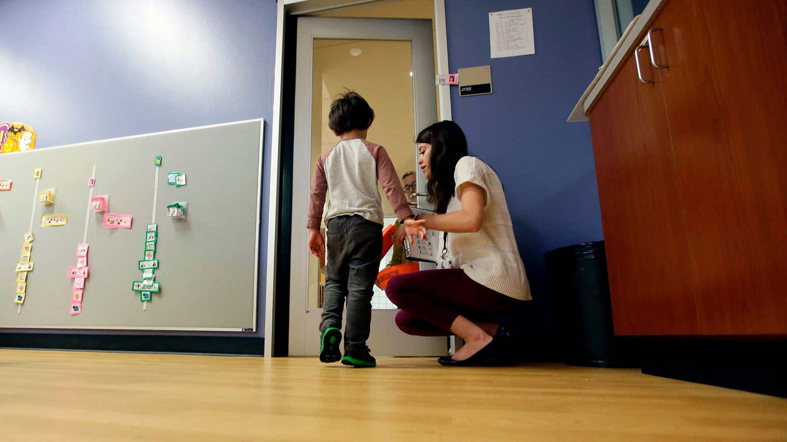 FILE – In this Monday, Oct. 24, 2016 file photo, Megan Krail helps a 4-year-old boy with Autism Spectrum Disorder practice trick-or-treating at The University…