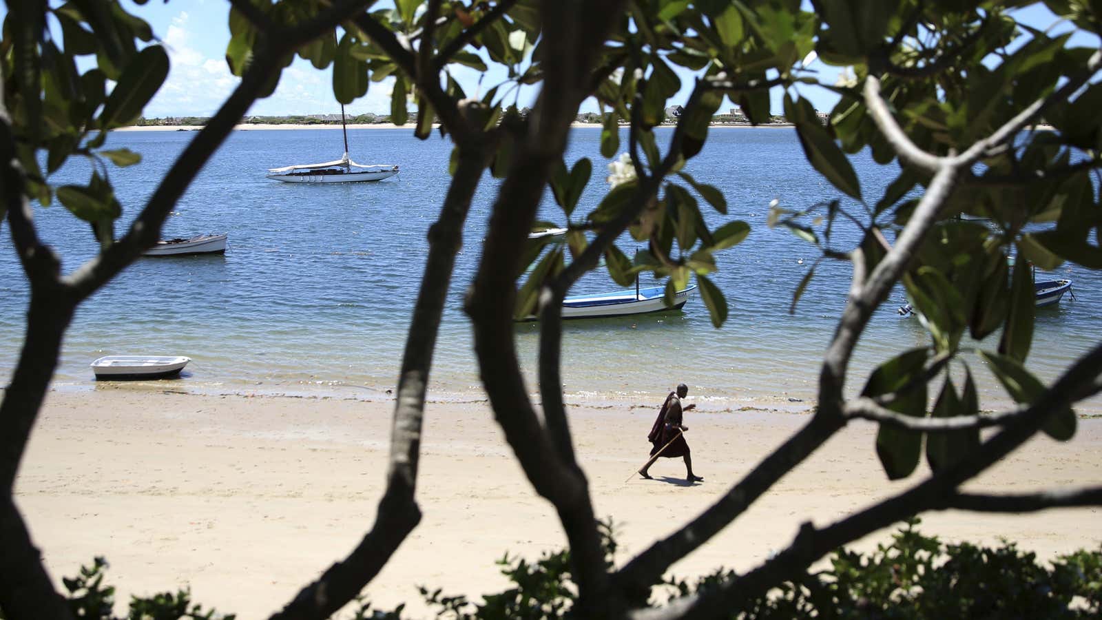 A Maasai man walks on Shela beach in Lamu, Kenya a key tourism spot