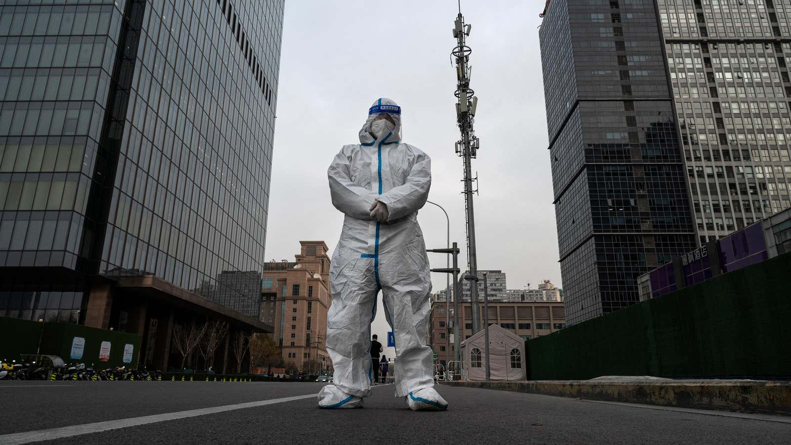 An epidemic control worker stands on an empty street in Beijing, China. 