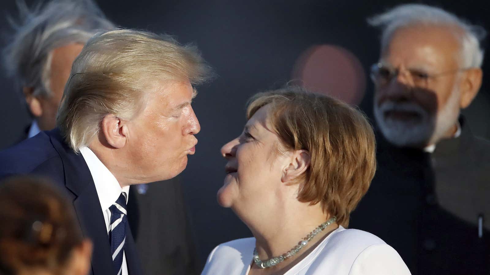President Donald Trump kisses German Chancellor Angela Merkel.