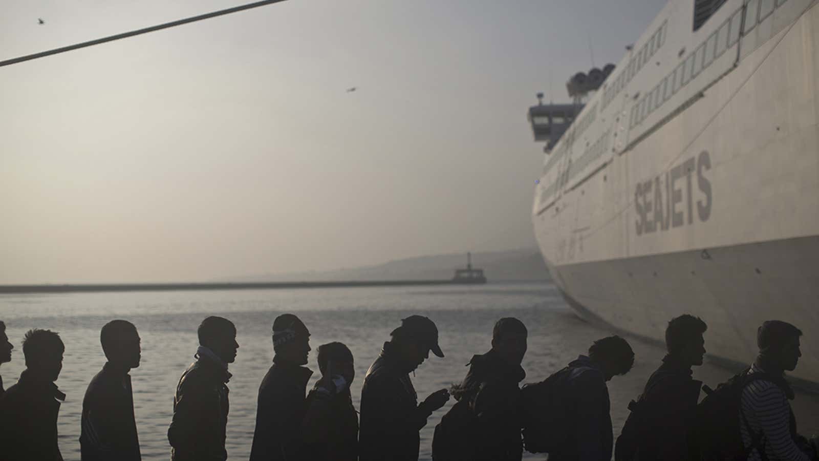 People queue in order to board a ferry at the port of Mytilene on the island of Lesbos, Greece