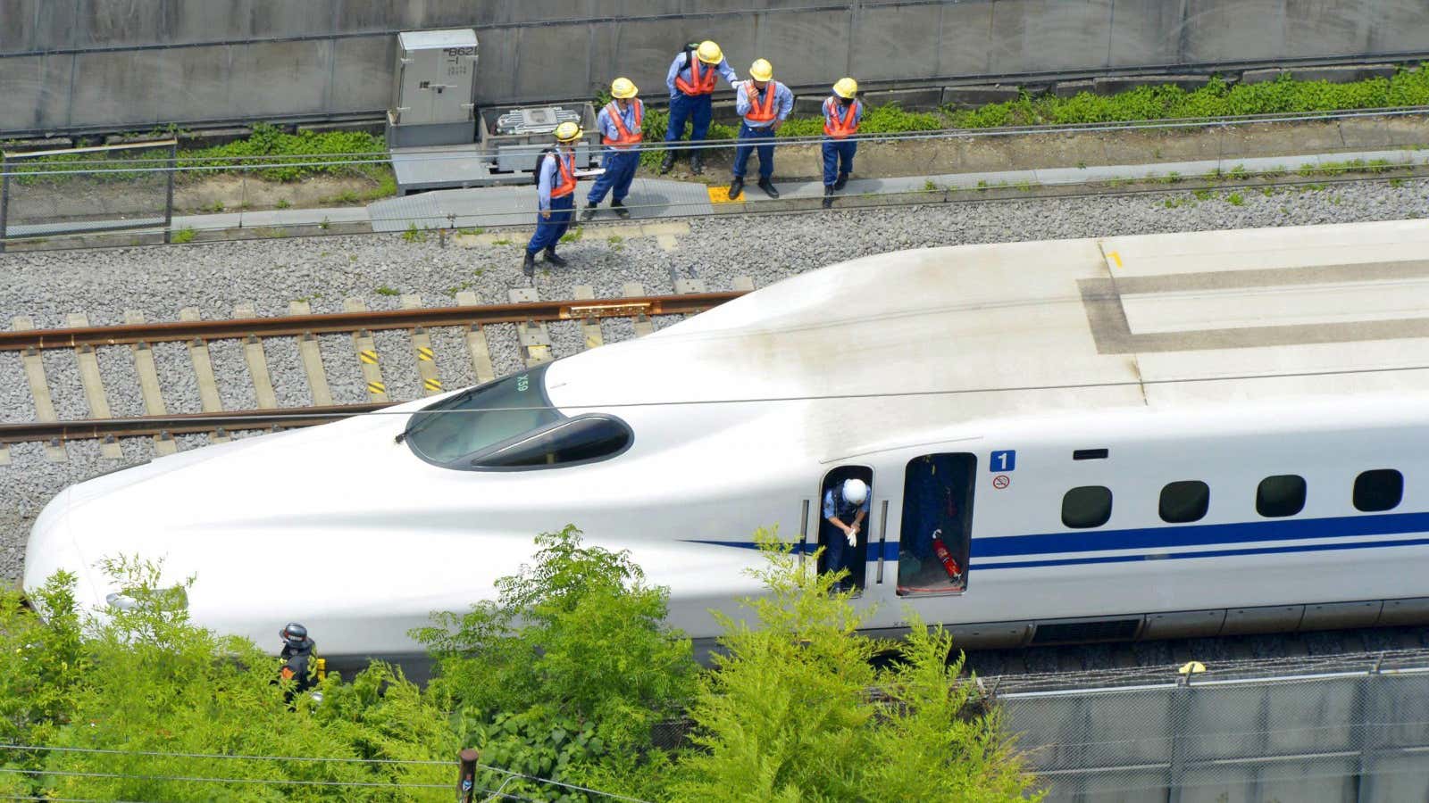 Police officers investigate a Shinkansen bullet train after it made an emergency stop in Odawara, south of Tokyo, in this aerial view photo taken by…