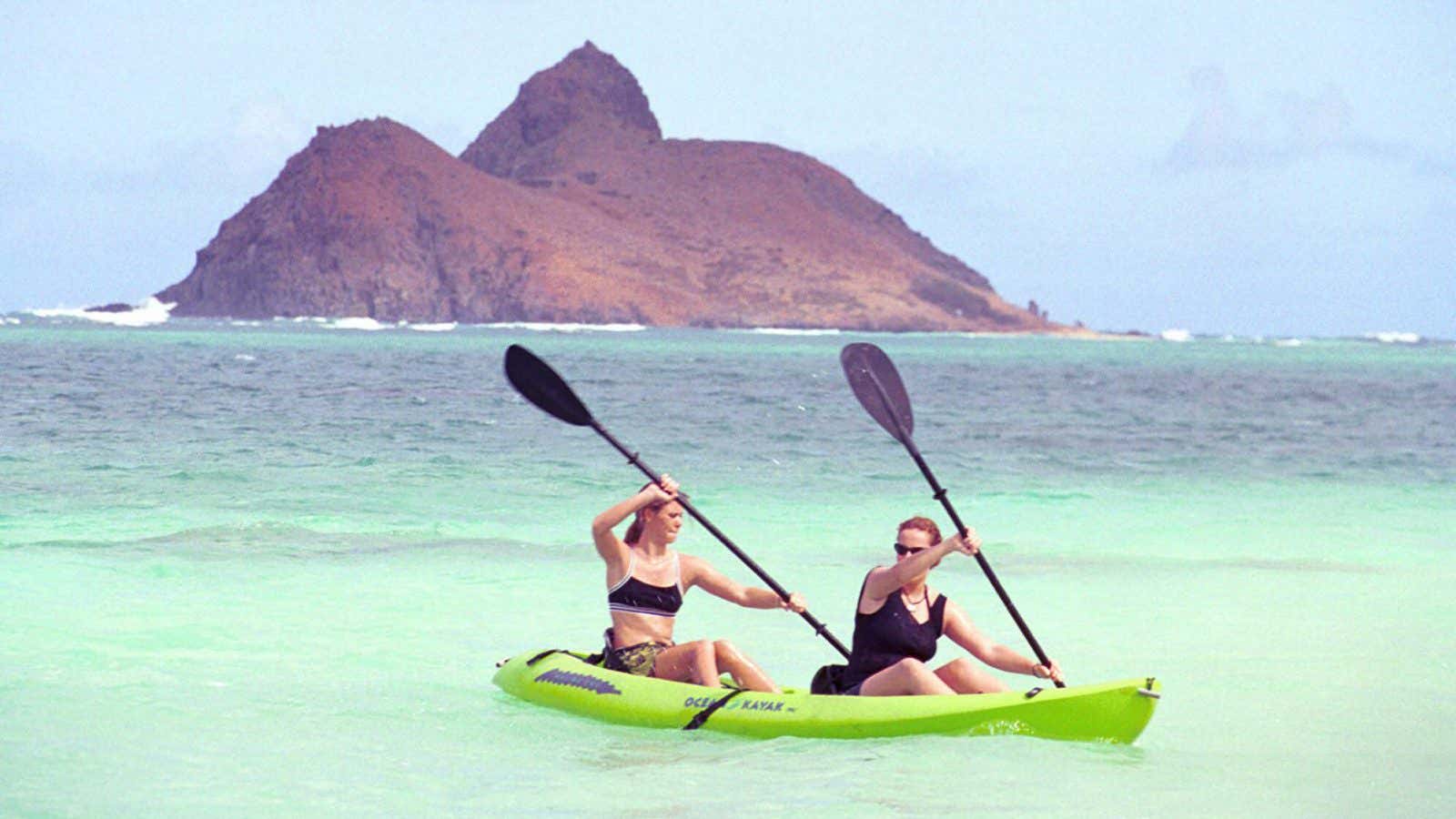 Two women make their way along the surf in Honolulu, Tuesday, May, 11, 1999. Visitors, military personnel and locals often underestimate the dangers of adventure…