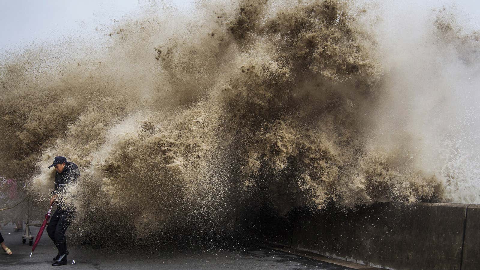 A man in Hangzhou, Zhejiang province, dodges tidal waves under the influence of Typhoon Usagi. Good thing he’s got that umbrella.