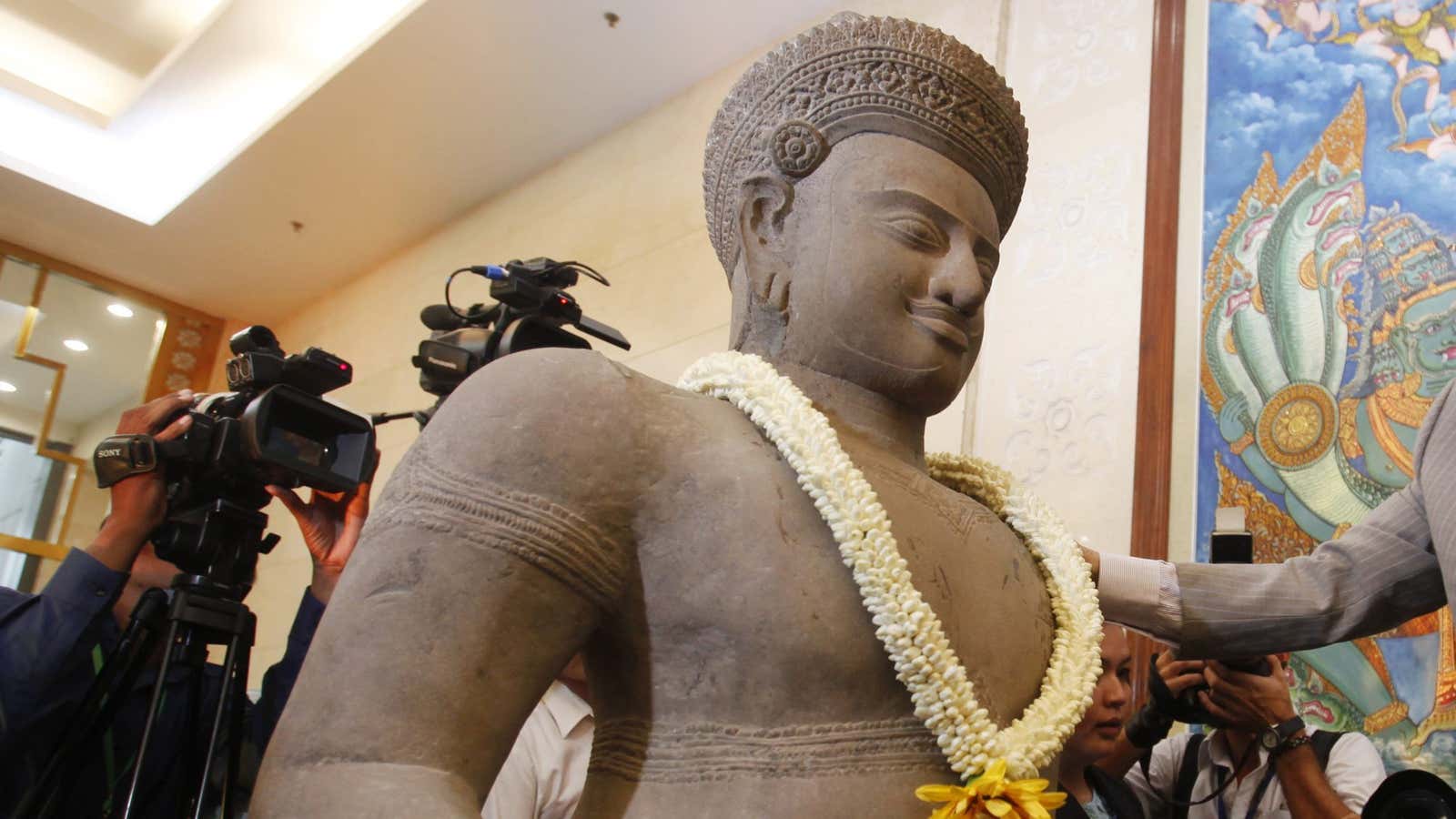 A looted statue is greeted by Cambodian officials after its return to to the country.