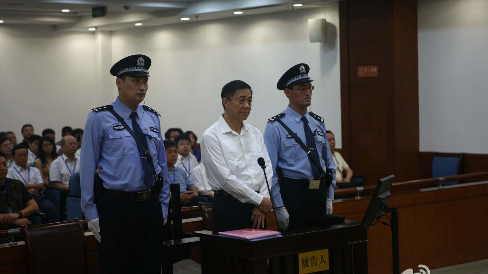 Bo Xilai seen flanked by policeman in court on Thursday.