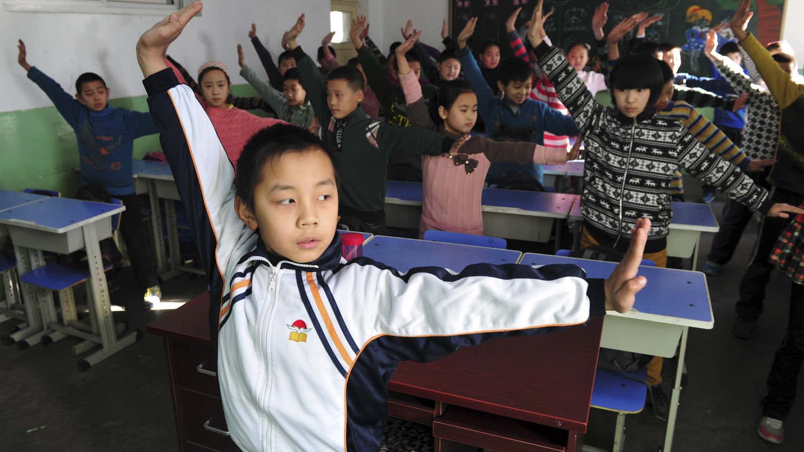 Pupils practice a set of martial arts “smog preventing” exercises in a classroom at a primary school in Shijiazhuang, Hebei province December 11, 2013. The…