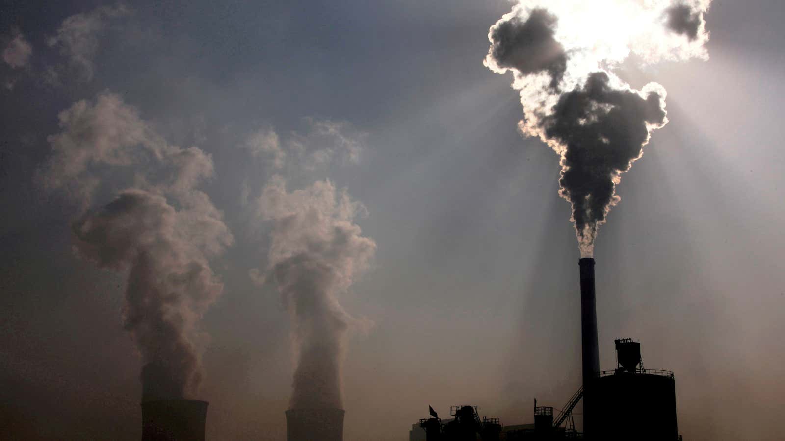 FILE PHOTO: A coal-burning power plant can be seen behind a factory in China’s Inner Mongolia Autonomous Region, October 31, 2010.