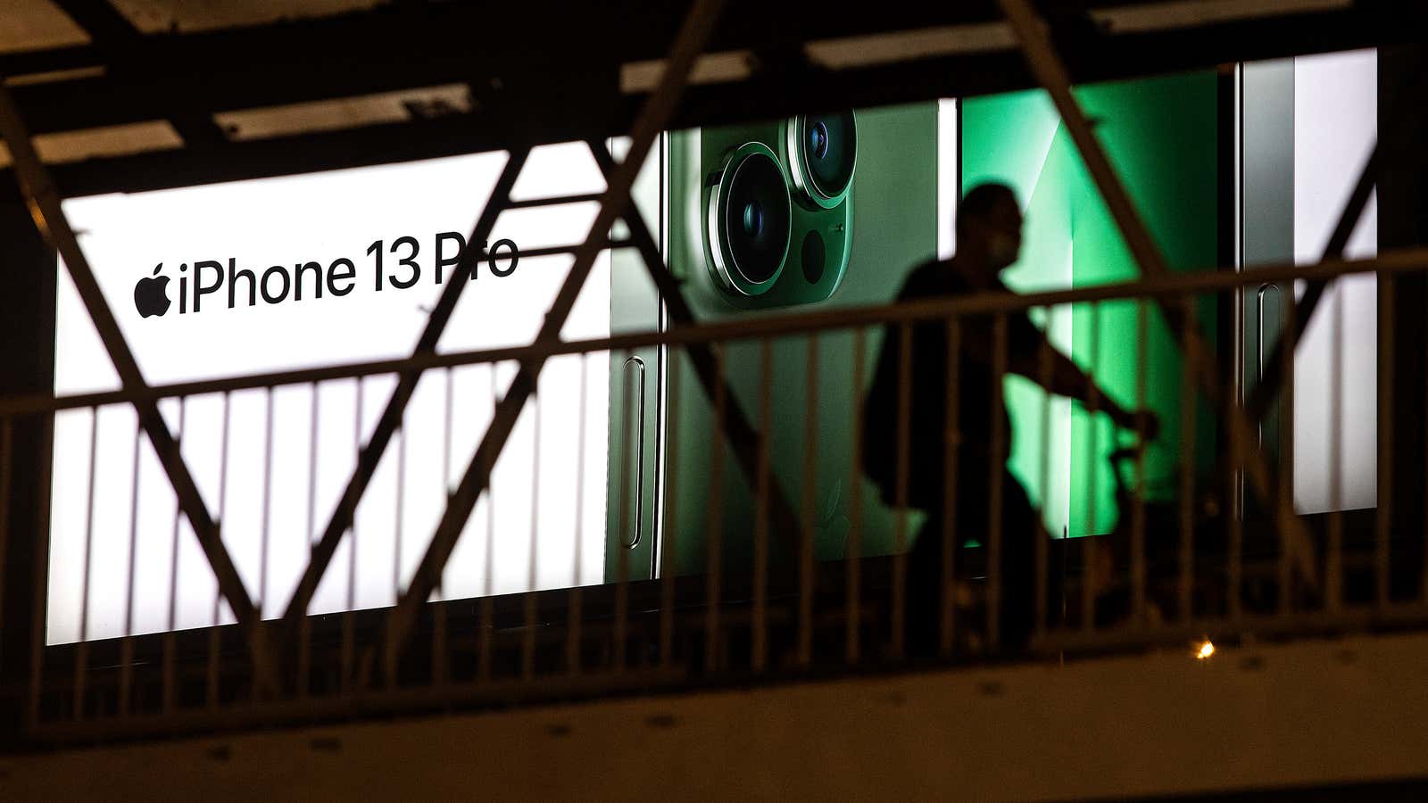 A person passes a large outdoor advertisement for the Apple iPhone 13 Pro on April 11, 2022 in Wuhan, Hubei province, China.