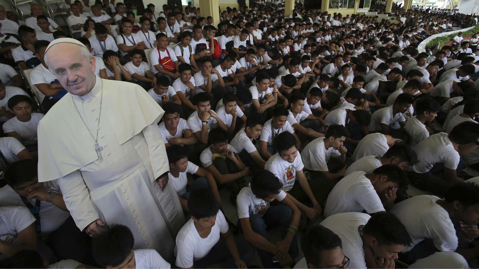 A cut-out picture of a standee of Pope Francis is surrounded by Filipino army reservist and volunteers during a briefing as part of security preparations for his visit.