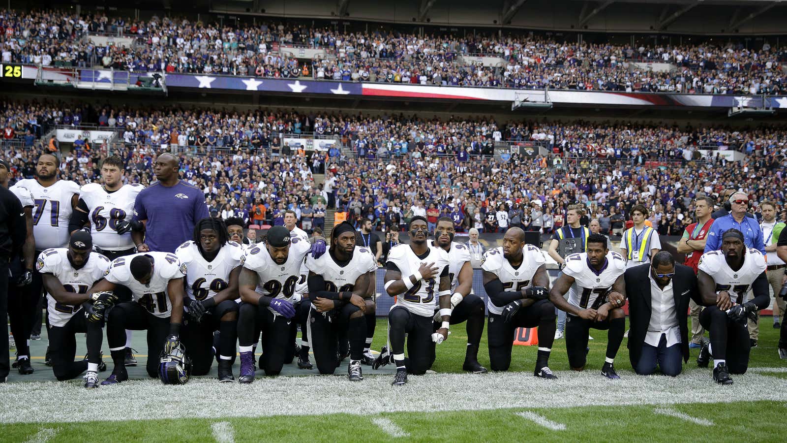 Baltimore Ravens players kneel down during the playing of the US national anthem before a Sunday NFL game.