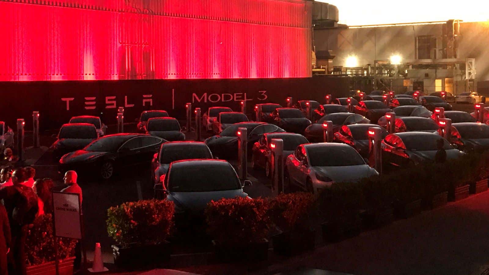 Model 3s wait outside the Tesla factory.