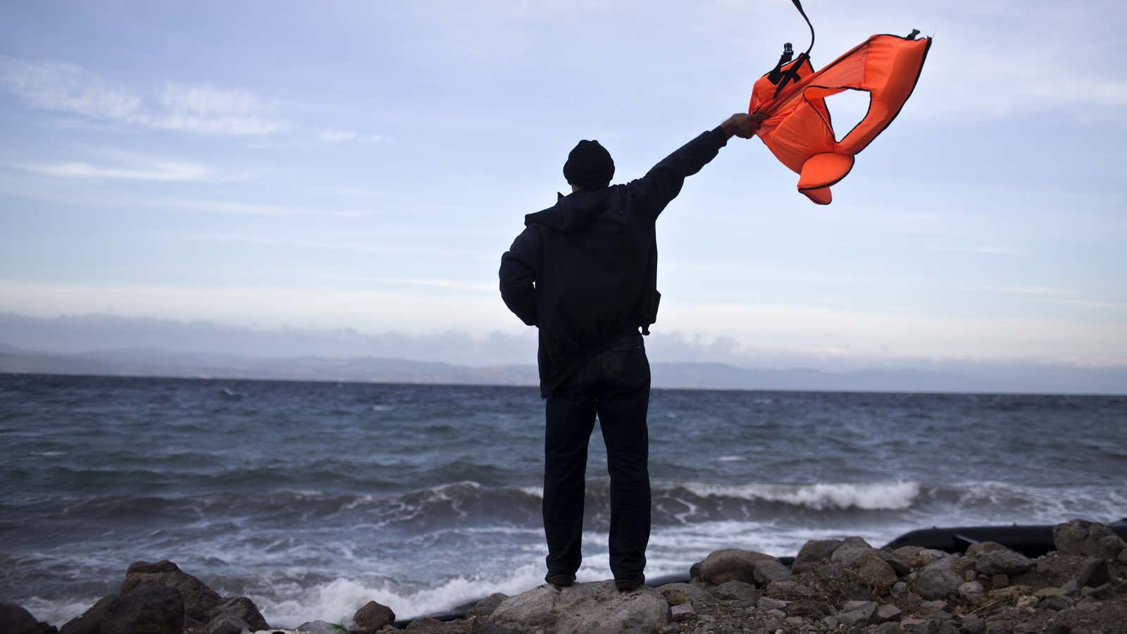 A local man in Lesbos signals an incoming boat full of refugees.