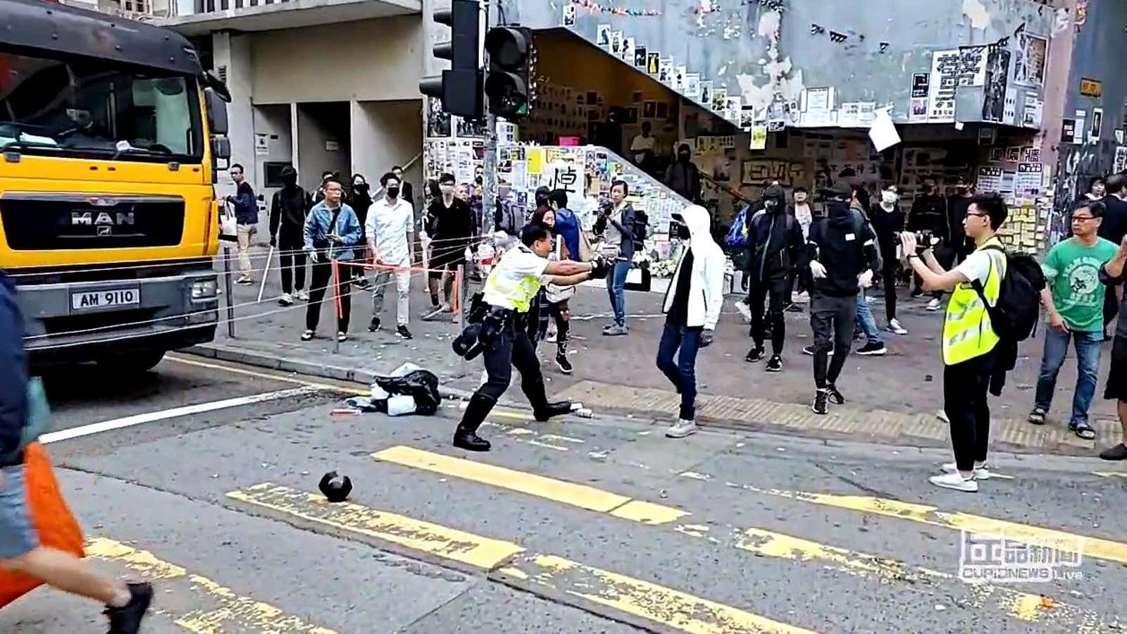 A still from a social media video shows a police officer aiming his gun at a protester.