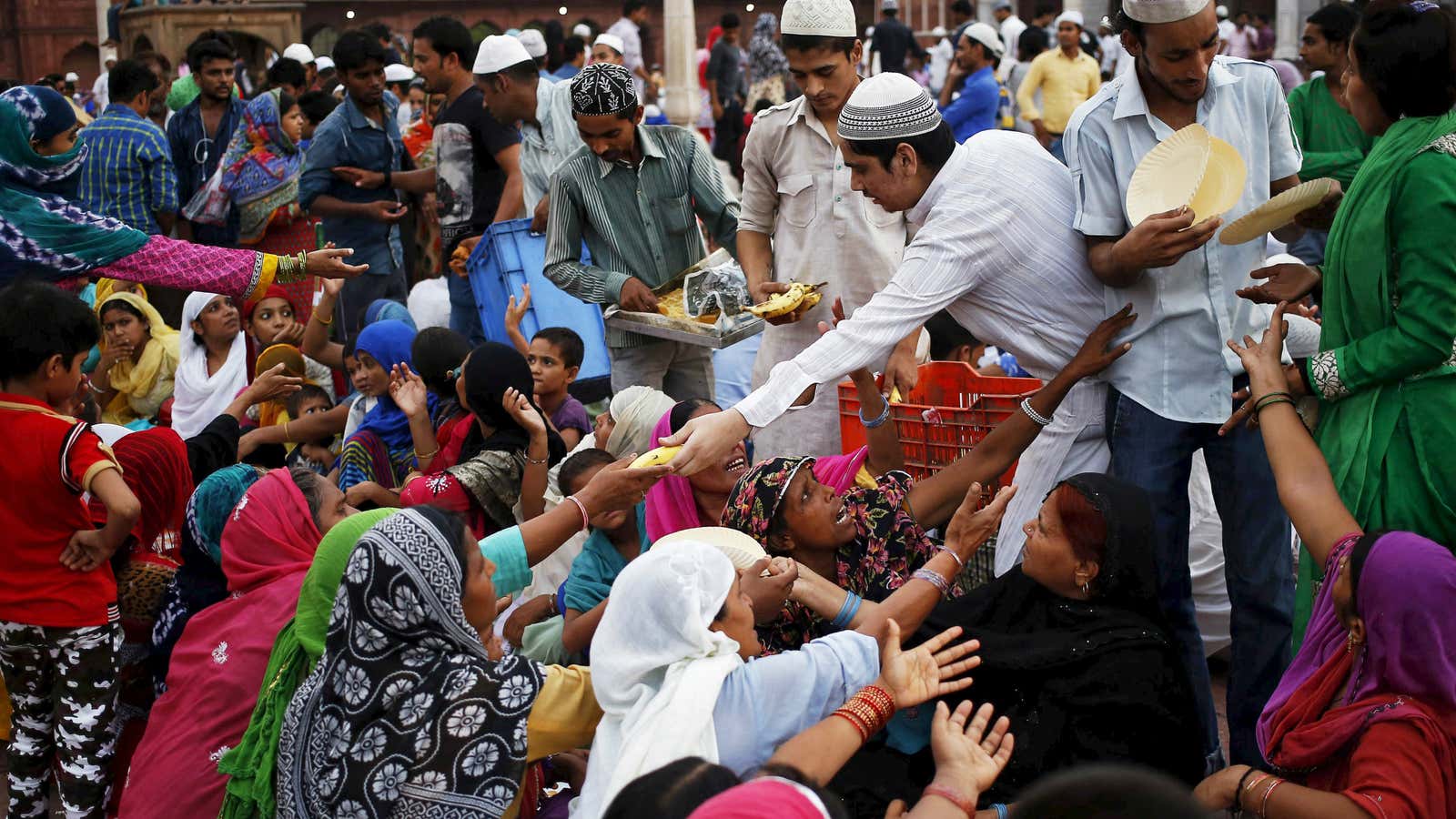 Muslims distribute free Iftar (breaking of fast) meals as charity during the holy month of Ramadan at the Jama Masjid (Grand Mosque) in the old…