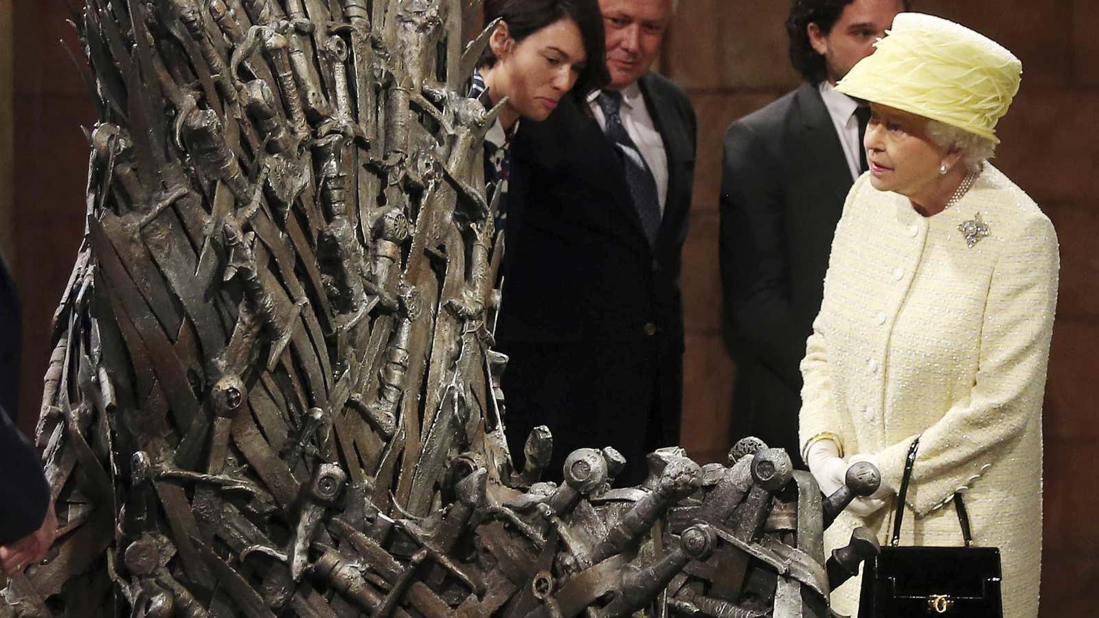 Britain’s Queen Elizabeth looks at the Iron Throne next to Game of Thrones cast members Kit Harington (2nd R), Conleth Hill (2nd L) and Lena…