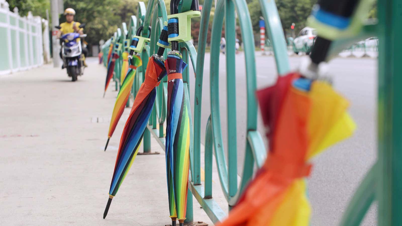 Rental umbrellas are attached to a fence, in the Pudong District in Shanghai, China.