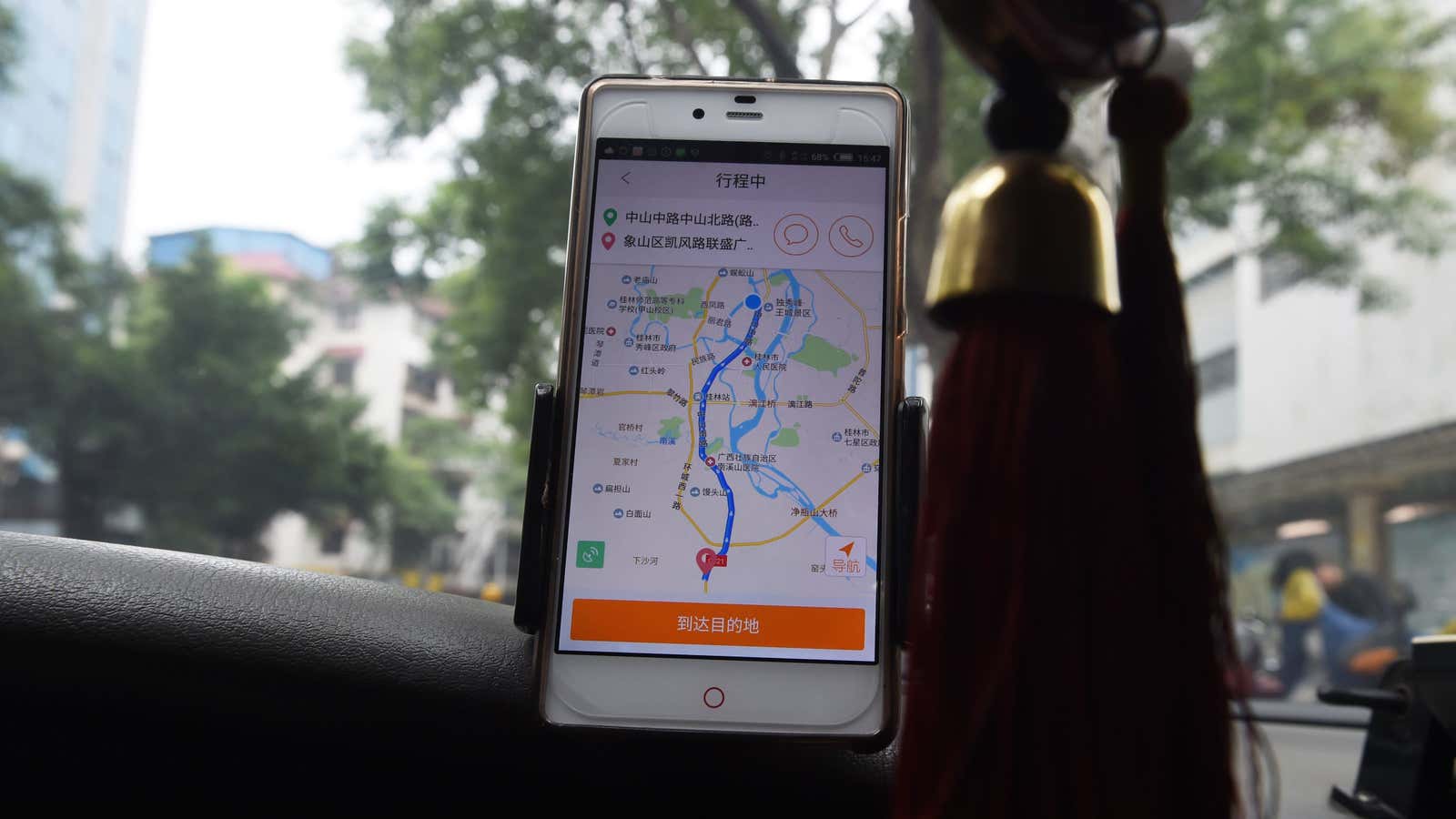 A taxi driver uses the Didi Chuxing app while driving along a street in Guilin, in China’s southern Guangxi region on May 13, 2016.