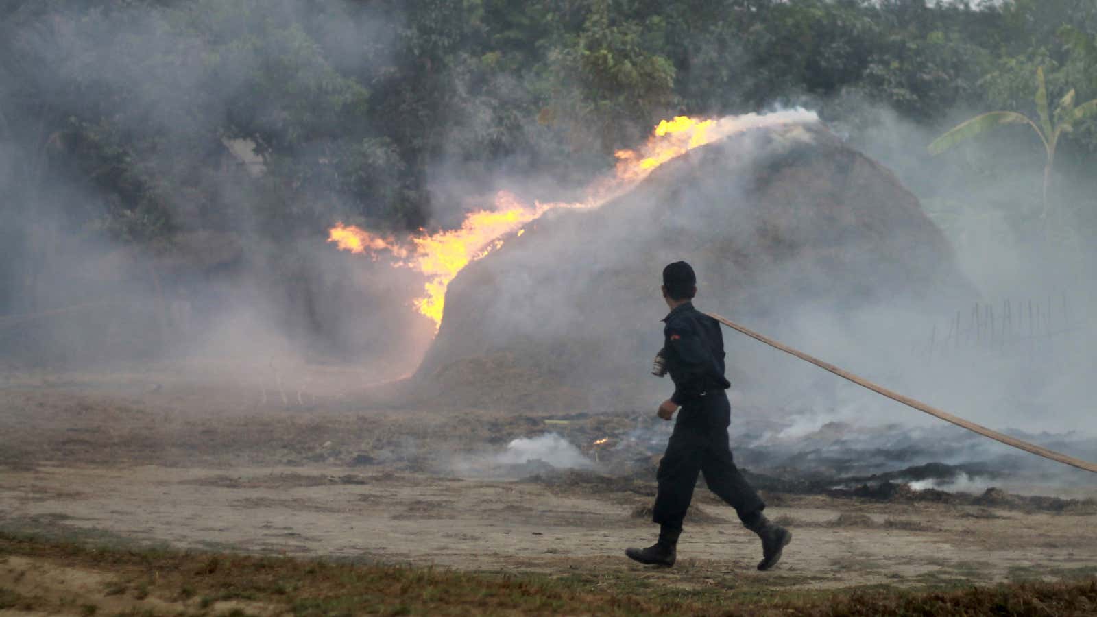 A firefighter runs towards a burning stock of hay which belongs to a Muslim household in Okkan, Myanmar.