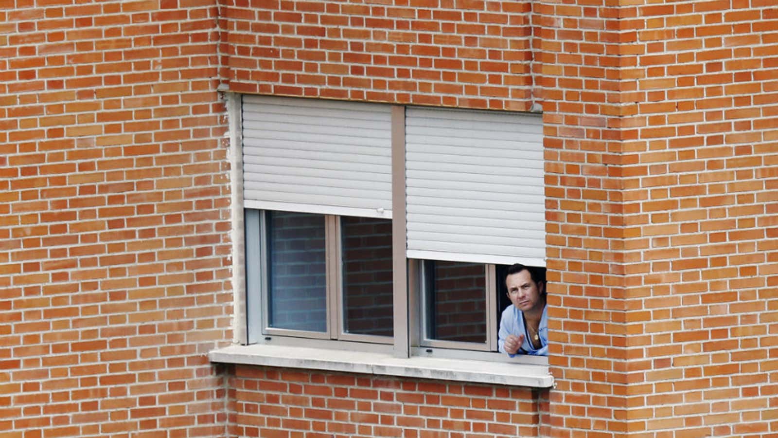 Javier Limon, the husband of Spanish nurse Teresa Romero Ramos who contracted Ebola, looks out of the window of a ward he is being kept isolated in.