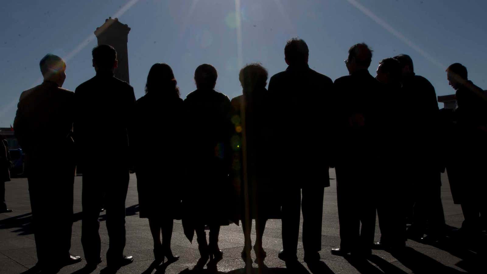 Delegates to China’s NPC pose in the dark, perhaps to hide their designer threads.