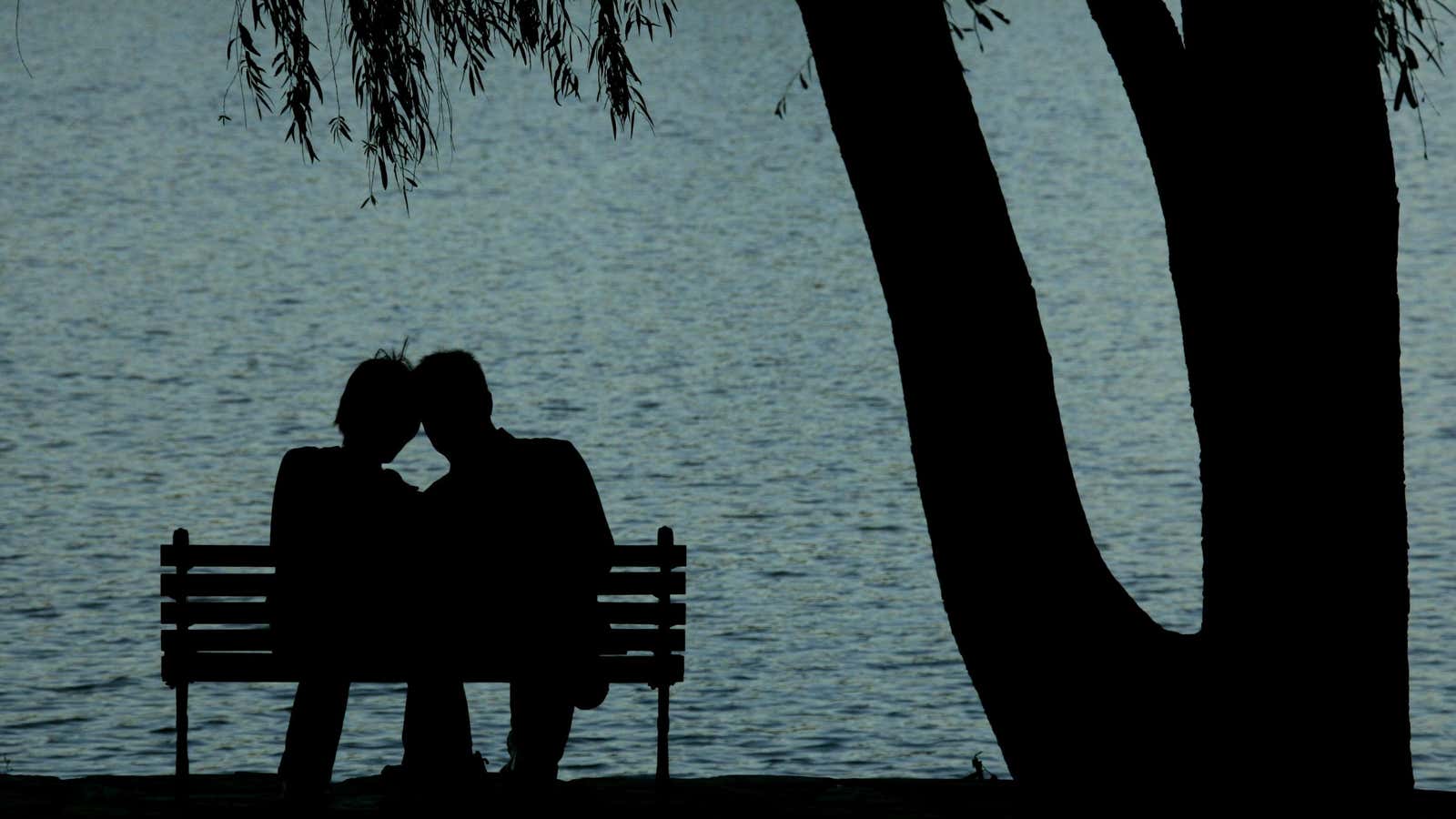 A pair of Chinese lovers rest beside a lake at a park in Beijing October 7, 2005. China celebrates a week-long National Day ‘Golden Week’…