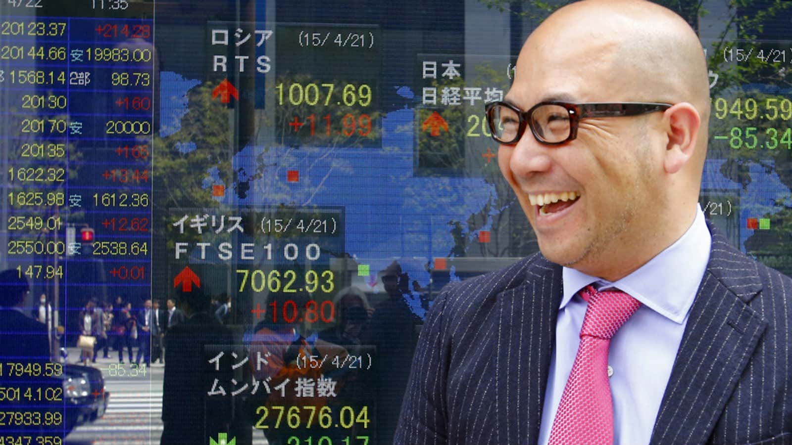 A man smiles in front of an electronic stock indicator of a securities firm in Tokyo.