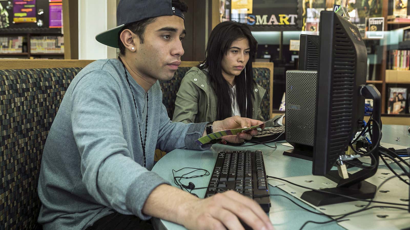 In this Wednesday, Jan. 8, 2014 photo, 19-year-olds Alexander Alegria and Michelle Rivera use computers at the Teen’Scape area at the Los Angeles Public Library…