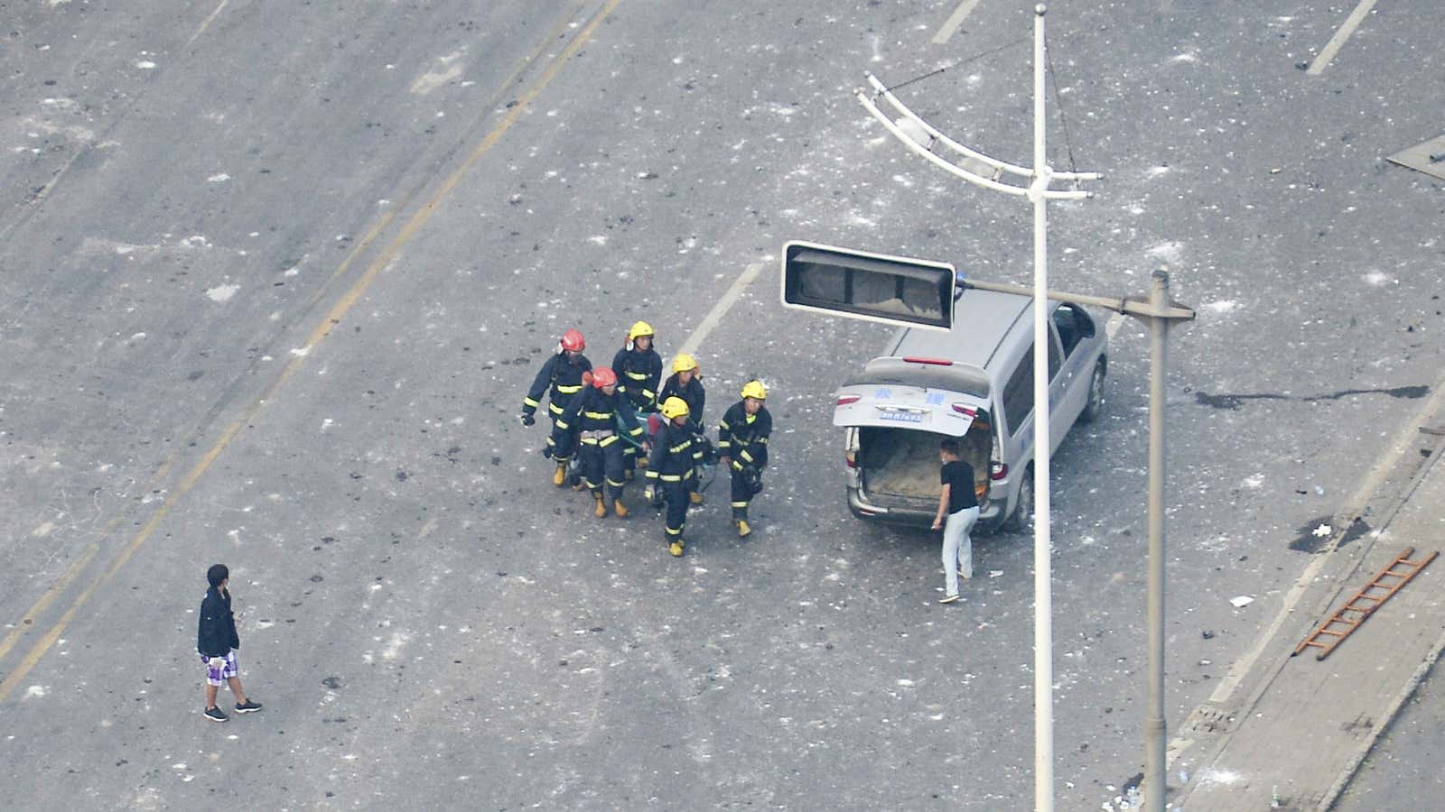 Firefighters carry the body of a victim after the Tianjin blasts.