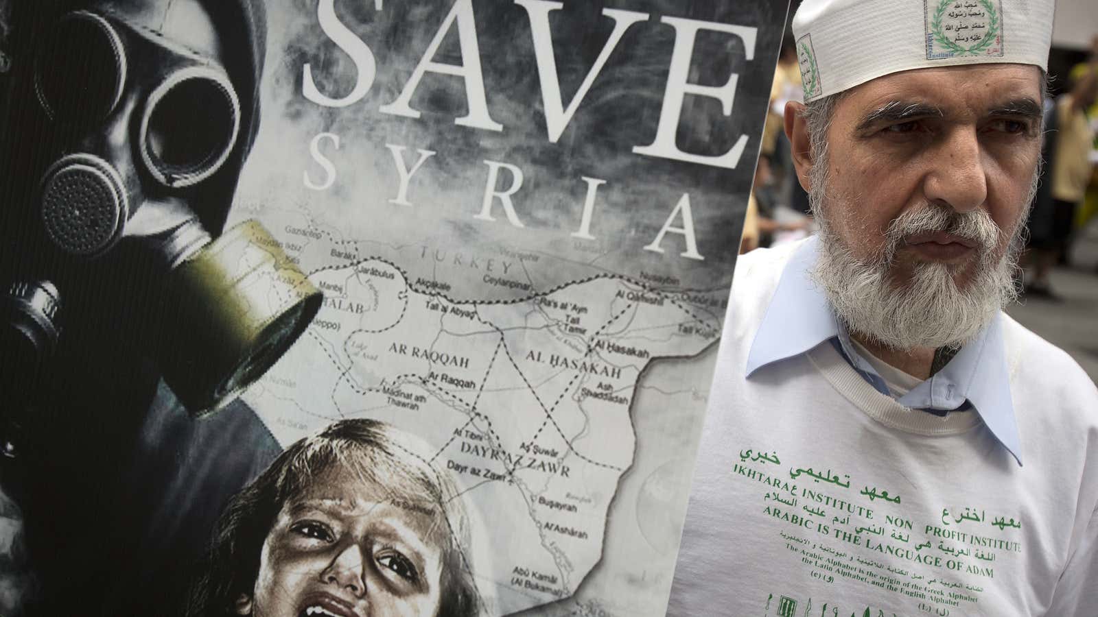 Protesters hold up signs during a demonstration marking the one-year anniversary of the chemical attacks in Syria, at Times Square in New York August 22, 2014.