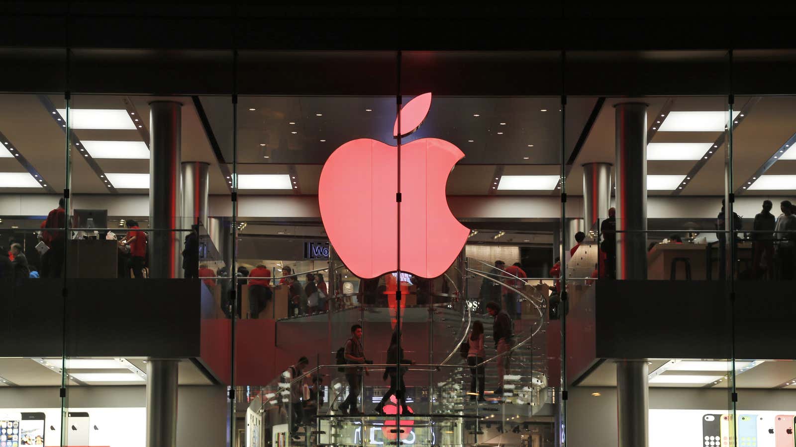 Shoppers visit the Apple store which changes its logo color to red in support for those living with HIV, in Hong Kong, during the World…