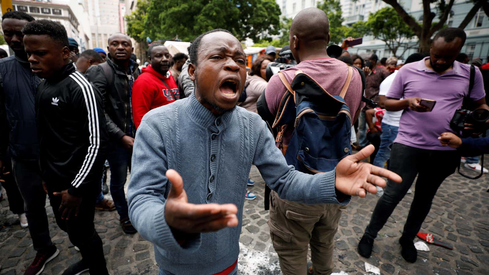 A refugee shouts at police after they were evicted from a sit in protest against xenophobia outside the United Nations High Commissioner for Refugees (UNHCR) offices in Cape Town, South Africa, Oct. 30, 2019.